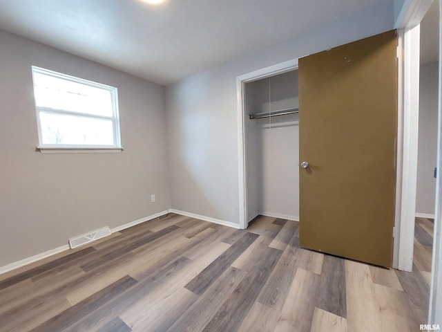 unfurnished bedroom with hardwood / wood-style floors and a closet