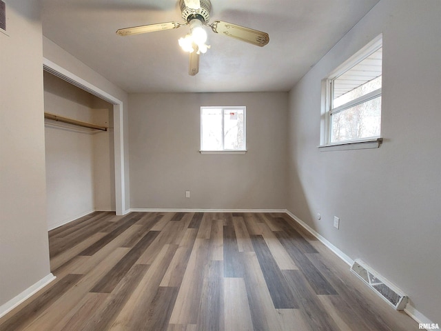 unfurnished bedroom featuring dark hardwood / wood-style floors, ceiling fan, and a closet