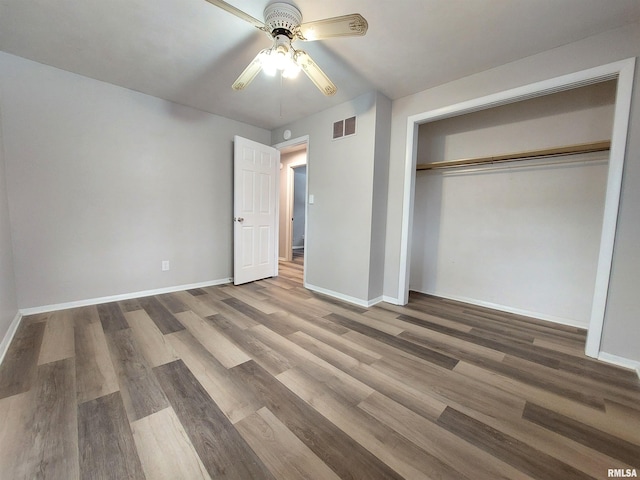 unfurnished bedroom featuring ceiling fan, wood-type flooring, and a closet