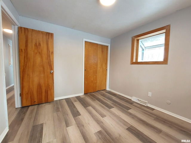 unfurnished bedroom featuring hardwood / wood-style flooring and a closet