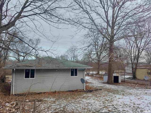 snow covered property featuring a storage unit