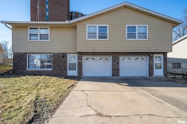 view of front of property featuring a garage, a front lawn, concrete driveway, and brick siding