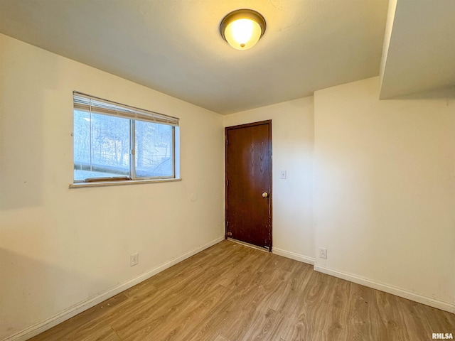 unfurnished room with baseboards and wood finished floors