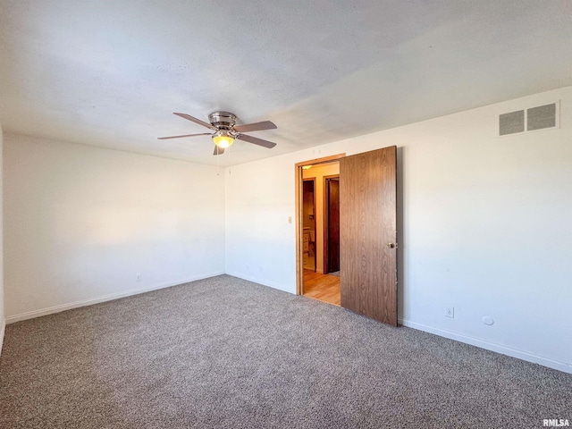 empty room with carpet floors, baseboards, visible vents, and a ceiling fan