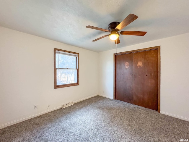 unfurnished bedroom with carpet, visible vents, ceiling fan, and baseboards