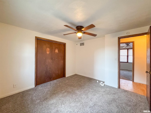 unfurnished bedroom featuring ceiling fan, carpet, and a closet