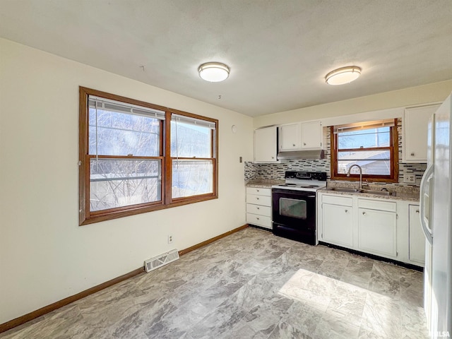 kitchen with electric range, a sink, visible vents, freestanding refrigerator, and decorative backsplash