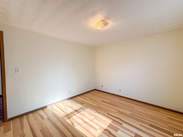 empty room with light wood-style flooring and baseboards