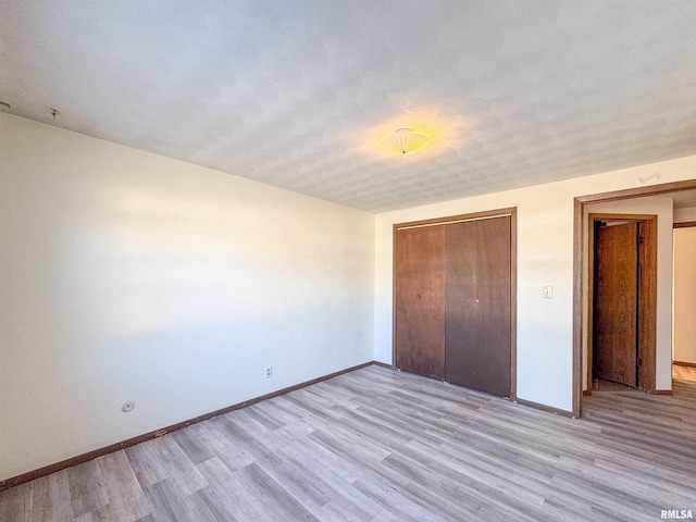 unfurnished bedroom featuring a closet and light wood-type flooring