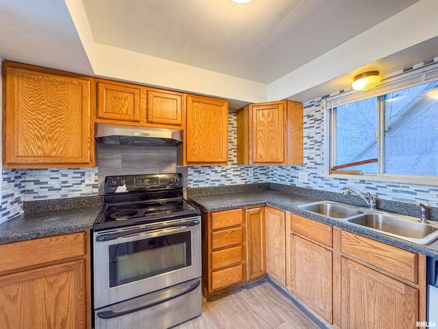 kitchen with tasteful backsplash, stainless steel electric range oven, sink, and light wood-type flooring