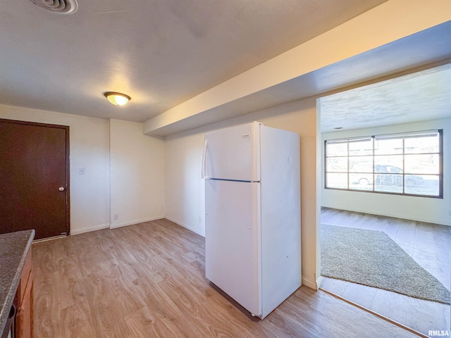 kitchen with light wood-type flooring and white fridge