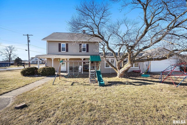 view of front of property with a playground and a front lawn