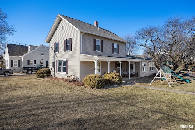 exterior space with a lawn, a playground, and a porch