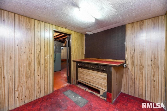 bar featuring stainless steel refrigerator and wood walls