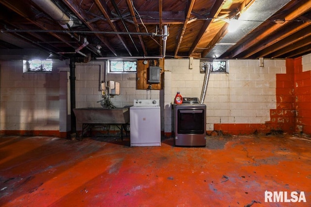 basement with sink, washer and clothes dryer, and electric panel