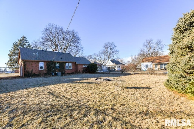 back of house featuring a yard and central air condition unit