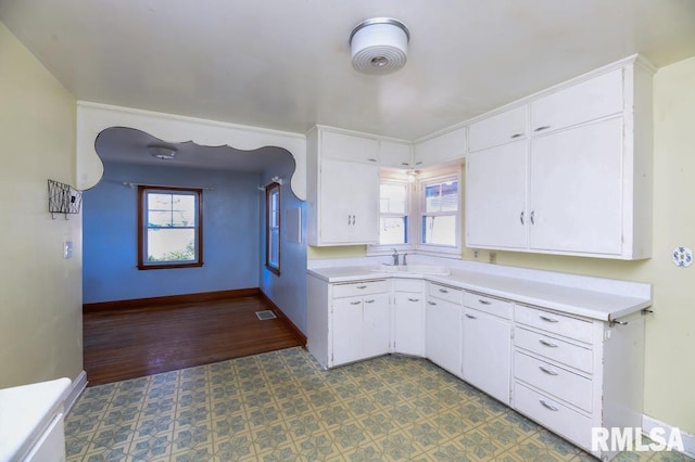 kitchen with white cabinetry, sink, and a wealth of natural light