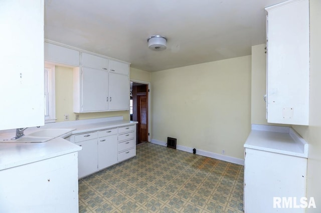 kitchen featuring white cabinetry and sink