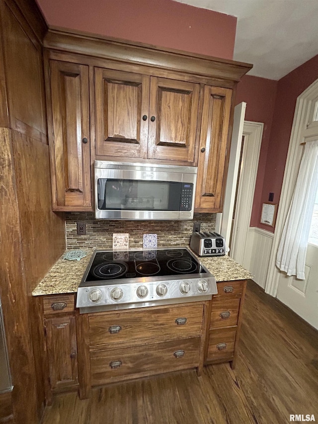 kitchen featuring light stone counters, dark hardwood / wood-style flooring, cooktop, and tasteful backsplash