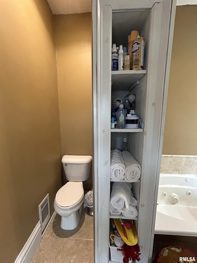 bathroom with toilet and tile patterned flooring