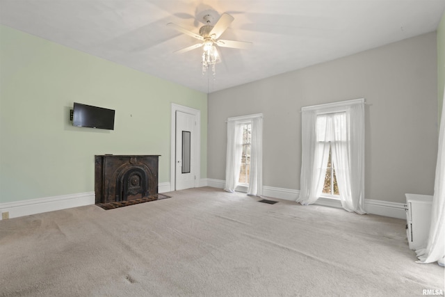 unfurnished living room with light colored carpet and ceiling fan