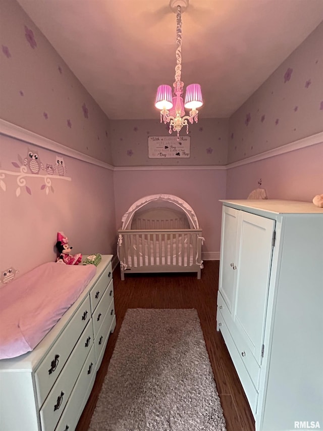 unfurnished bedroom with dark wood-type flooring and an inviting chandelier