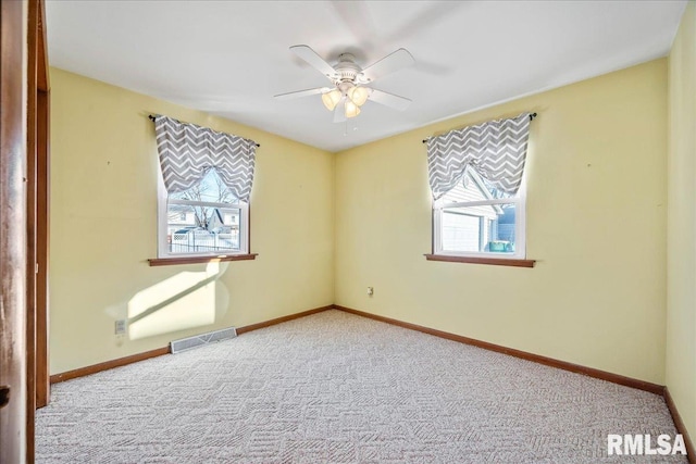 additional living space featuring a wealth of natural light, light carpet, and ceiling fan