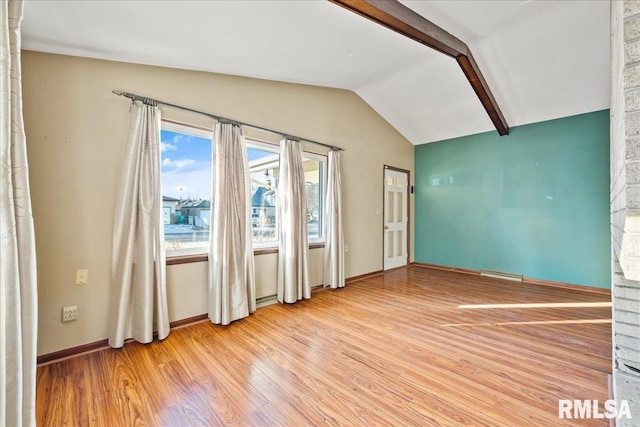 empty room featuring hardwood / wood-style floors and vaulted ceiling