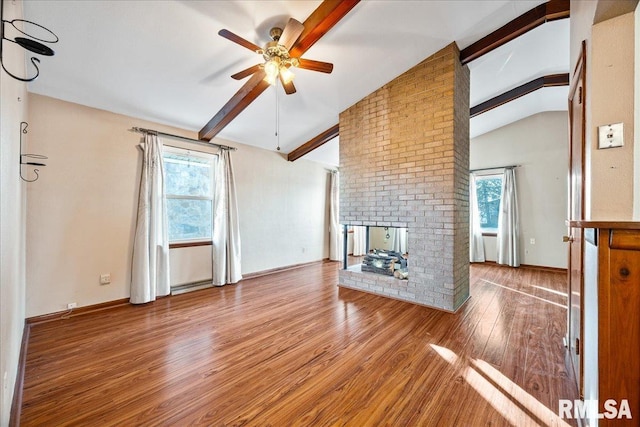 unfurnished living room with lofted ceiling with beams, wood-type flooring, a wealth of natural light, and a fireplace