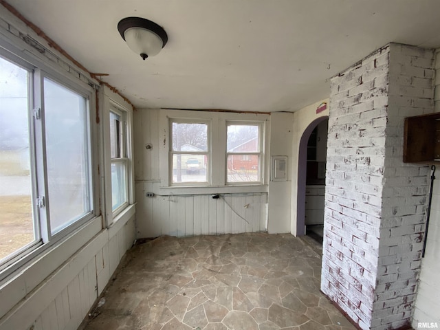 empty room featuring brick wall