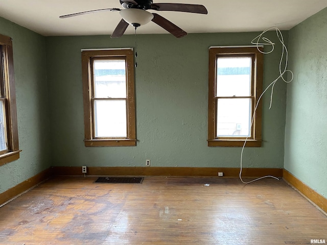 empty room with ceiling fan and wood-type flooring