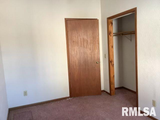 unfurnished bedroom with carpet and a closet