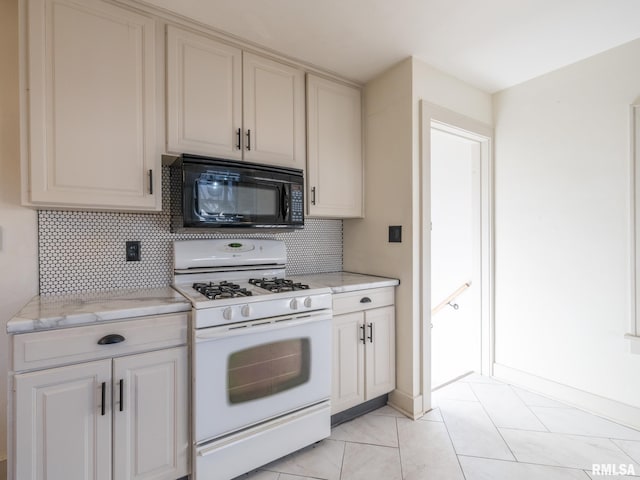 kitchen with white range with gas cooktop, light tile patterned floors, decorative backsplash, and light stone countertops