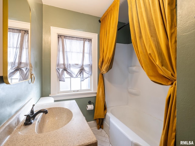 bathroom featuring tile patterned floors, a healthy amount of sunlight, shower / bath combo with shower curtain, and vanity