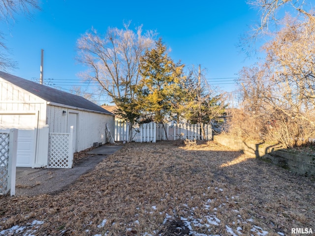 view of yard featuring a garage and an outbuilding