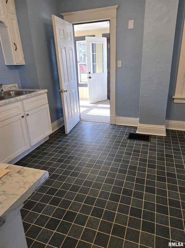 interior space featuring white cabinetry and sink