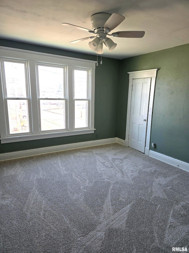 empty room with ceiling fan and carpet flooring