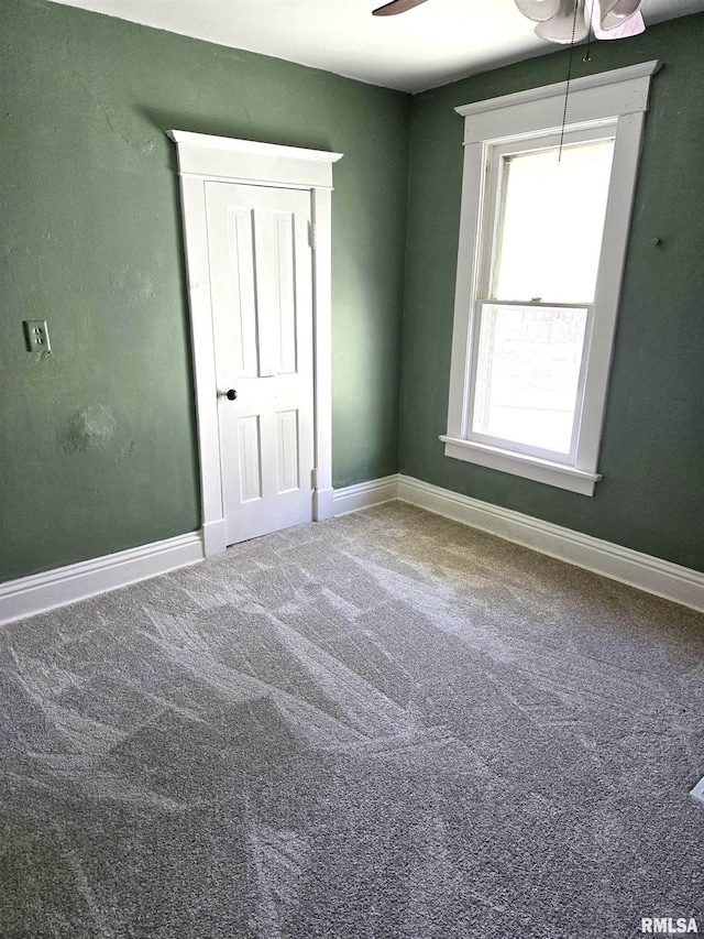 carpeted spare room featuring ceiling fan