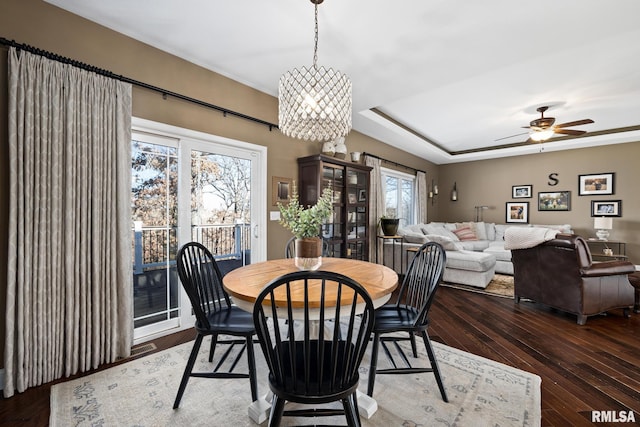 dining room featuring a tray ceiling, french doors, dark wood finished floors, and ceiling fan with notable chandelier