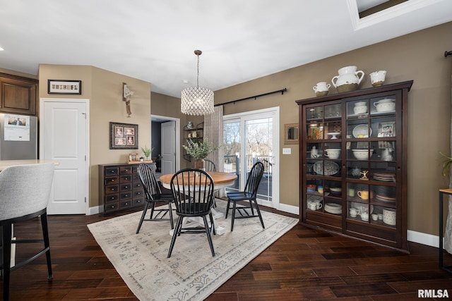 dining area featuring dark wood-type flooring and baseboards