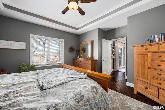 bedroom featuring dark wood-style flooring, a ceiling fan, and baseboards