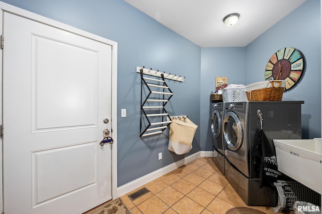 washroom featuring laundry area, light tile patterned floors, baseboards, visible vents, and independent washer and dryer