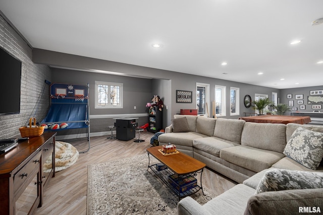 living room featuring baseboards, brick wall, light wood finished floors, and recessed lighting