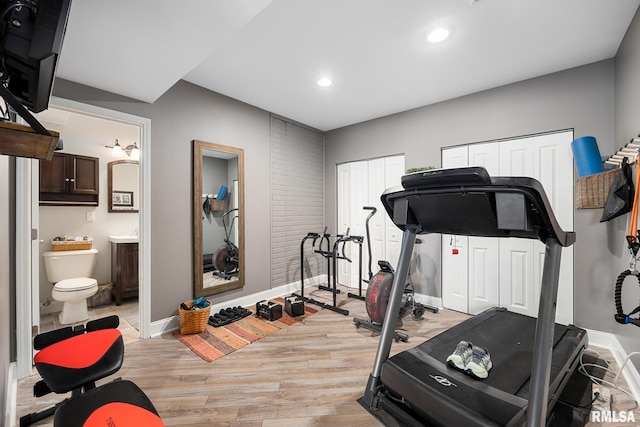 exercise room with light wood-style floors, baseboards, and recessed lighting