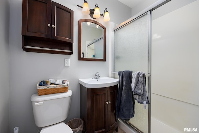 full bathroom featuring toilet, a stall shower, and vanity