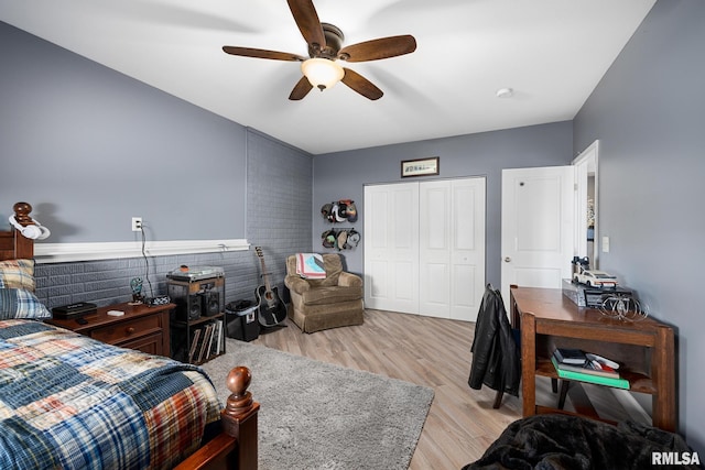 bedroom featuring light wood-type flooring, ceiling fan, and a closet