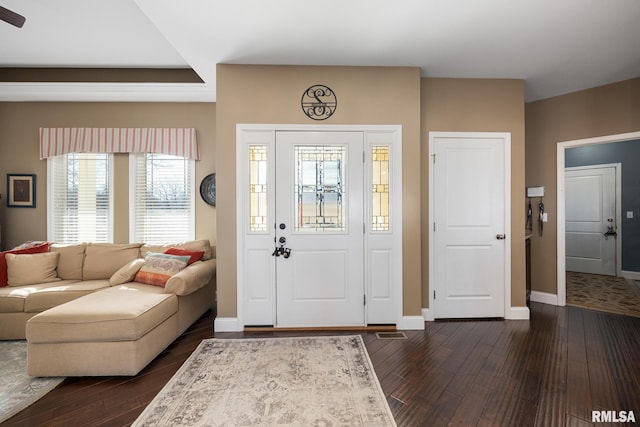 entryway with dark wood-style flooring, visible vents, and baseboards