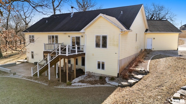 back of house with a deck, roof with shingles, and stairway