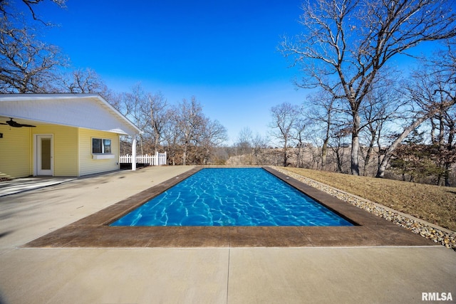 outdoor pool featuring a patio area, fence, and a ceiling fan