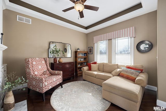 living room with crown molding, visible vents, a ceiling fan, wood finished floors, and baseboards